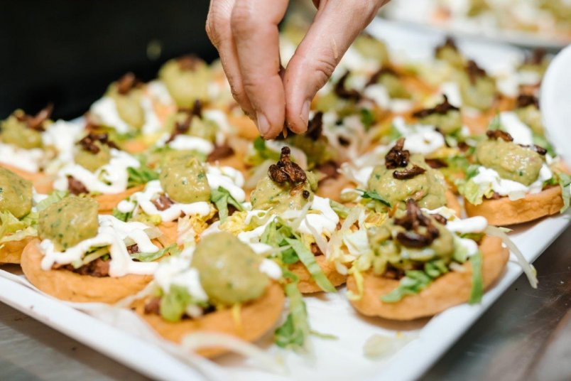 Feed Me Loco at Besos Latinos for American Express Restaurant Month 2018. Artisanal ground maize corncake topped with refried beans, lettuce, sour cream, guacamole and roasted crickets. Image: Sacha Stejko